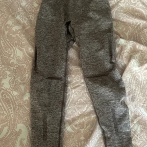 Gråa seamless leggings från ICANIWILL - Säljer ett par gråa seamless leggings från ICANIWILL. De har snygga mesh-detaljer längs benen och är tillverkade i ett stretchigt syntetmaterial som sitter tight och bekvämt. Perfekta för gymmet eller annan träning. Hög midja för extra support.