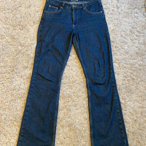 Blå bootcut jeans från Gina Tricot - Snygga mörkblå bootcut jeans från Gina Tricot, modell Perfect Jeans. Klassisk femficksdesign, hög midja och raka ben med lätt utsvängning. Jeansen är i ett mjukt denimtyg som sitter skönt och passar till många olika stilar.