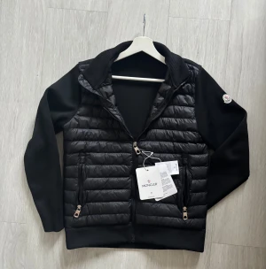 Moncler cardigan  - Moncler hybrid cardigan (höst/vår) jacka. Helt ny och oanvänd håller också varm vid blåsig väder. Säljer pågrund av liten storlek. Hör av er vid funderingar. :)