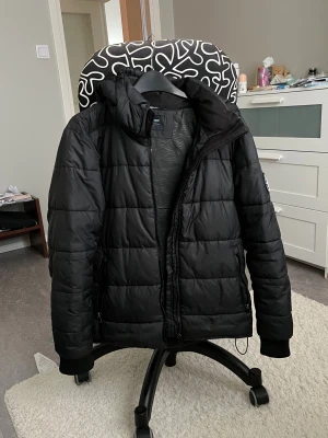 Everest vinterjacka / dunjacka - Vinterjacka från everst. Storlek 158 dvs 79 cm bröst. Borttagbar huva och två fickor på utsidan samt en ficka på insidan. Justerbar tightness vid nedre änden (se sista bild). För frågor eller fler bilder är det bara att skriva till mig!