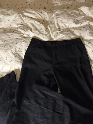 Svarta kostymbyxor från Zara - Superfina svarta kostymbyxor från Zara. Endast använda vid fåtal tillfällen! Storlek L men mer som en M. Jag har gjort små hål längst fram på insidan (inget man lägger märke till se bild 5) där jag hade ett snöre för att knyta åt de i midjan🤍. 