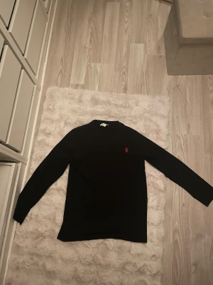 Svart långärmad tröja Burberry - Svart långärmad tröja från Burberry med röd broderad TB-logga på bröstet. 