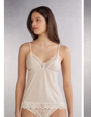 Satin linne med spets  - Satin linne med spets, ljusrosa/champange likande färg. Ena axelbandet har lyckats tvista sig aningens 