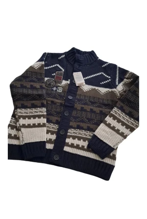 Mönstrad kofta från Camp David, M/L - Snygg stickad kofta från Camp David med coola badges och knappar framtill. Färgerna är mörkblå, beige och brun i ett grafiskt mönster. Hög krage och långa ärmar. Materialet är 80% ull och 20% yak, vilket gör den extra mjuk och varm. Perfekt för dig som gillar outdoor-vibe.