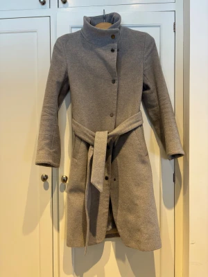Ljusgrå kappa Tiger of Sweden - En fin kappa som hängt med några år men sparsamt använd till/från kontoret. Har mer att ge.