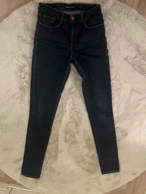 Levi's mörkblå skinny jeans  - Snygga mörkblå skinny jeans från Levi's. klassiska fem fickor. Jeansen har kontrastsömmar, knapp och dragkedja fram samt Levi's logga på bakfickan. Perfekt passform som sitter tight hela vägen ner.