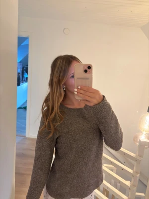 Brun stickad tröja - Mysig brun stickad tröja från Vero Moda med en enkel och klassisk design med ribbade muddar vid ärmslut och nederkant. Använd fåtal gånger! 