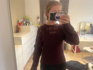 Vinröd stickad tröja med spets från Zara strl S - Säljer en vinröd stickad tröja från Zara i storlek S. Tröjan har snygga spetsdetaljer och hålmönster över axlar och ärmar, samt ribbad nederkant och ärmslut. Perfekt för dig som gillar unika detaljer och vill ha en mysig men stilren look.