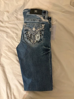 Miss Me bootcut jeans🙏🏼 - Snygga blå jeans från Miss Me med bootcut passform. Jeansen har coola detaljer med broderad bakficka, stjärnor, pärlor och slitningar. Kontrastsömmar och silverfärgade knappar ger extra edge. Perfekt för dig som gillar statement-jeans. Aldrig använda, helt nya.