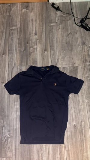 Marinblå pikétröja Polo Ralph Lauren - Snygg marinblå pikétröja från Polo Ralph Lauren. Den är helt ny och köpt av en leverantör.