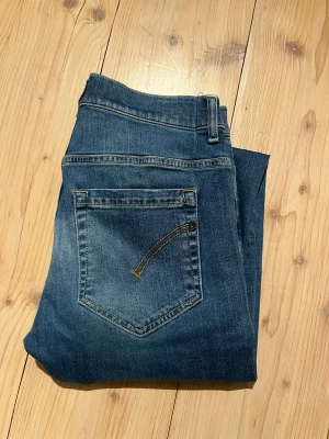 Blå jeans från Dondup D-Zero - Snygga blå jeans från Dondup D-Zero med klassisk femficksdesign och diskreta slitningar. Jeansen har normal passform, raka ben och är tillverkade i mjukt denimtyg med lite stretch. Perfekta för dig som gillar en stilren och avslappnad look.