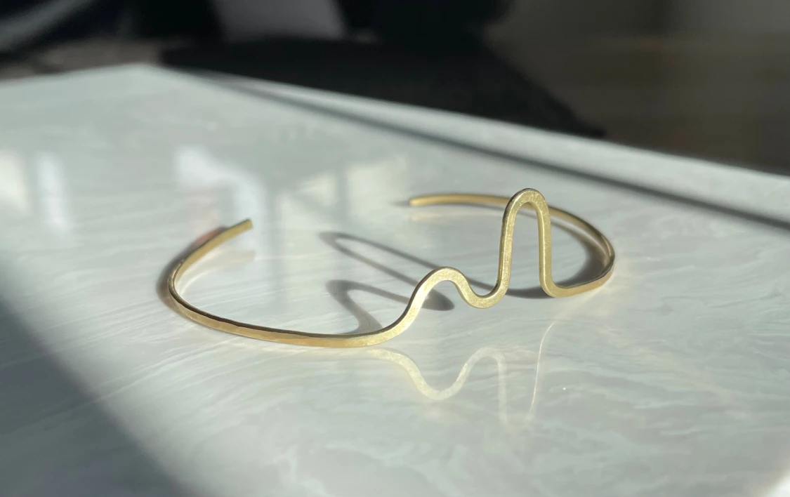 Guldigt minimalistiskt armband vågform