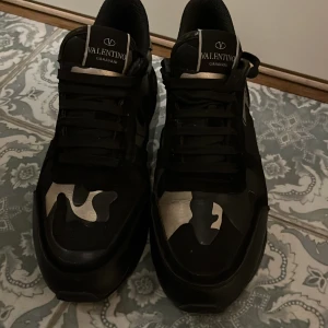 Valentino rock Runners  - Svarta sneakers från Valentino Garavani med coolt kamouflagemönster i silver på tån. Skorna har snörning. skorna är mycket bra skick ny pris 7 tusen. skriv vid flera frågor 🤩