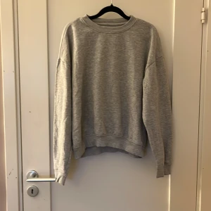 Grå sweatshirt från 157, storlek S - Enkel och stilren grå sweatshirt från 157 i storlek S. Tröjan har rund halsringning, ribbade muddar och är tillverkad i mjuk bomullsblandning. Perfekt för en chill och avslappnad look.