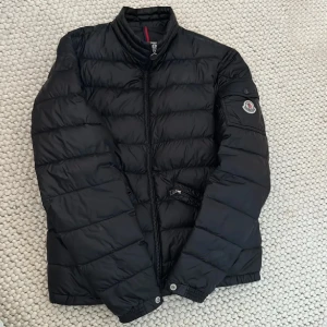 Svart dunjacka från Moncler - Säljer nu denna sjukt snygga Moncler agay jackan som är helt perfekt nu till hösten, förutom en lagning som finns på ena ärmen som ej märks av och är ytterst liten, annars är jackan i toppskick, tveka inte att höra av vid frågor! Mvh