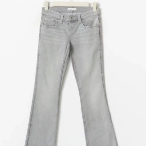 Grå bootcut jeans från gina - Snygga ljusgrå jeans från gina med bootcut passform och klassisk femficksdesign. Jeansen har låg midja. Lappen sitter kvar då jeansen aldrig används 