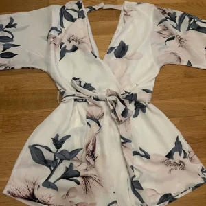 Blommig romper - Romper med blommigt mönster i grönt och ljusrosa.