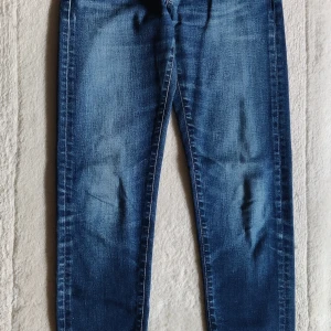 Blå skinny jeans i stretch - Snygga blå jeans med skinny passform och lätt tvättade detaljer. Jeansen är tillverkade i stretchigt denimtyg som sitter tajt längs benen och har klassisk femficksdesign. Perfekta för dig som gillar en smal siluett och vill ha bekväma jeans i vardagen.