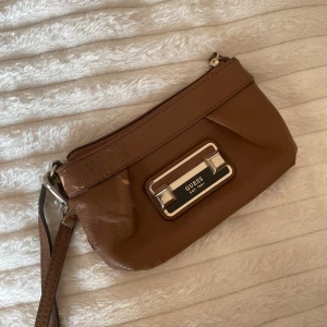 GUESS Wristlet  - Välanvänd, lädret har börjat flagna på en del ställen. Mer att ge men som sagt, välanvänd. 20kr. Äkta Guess