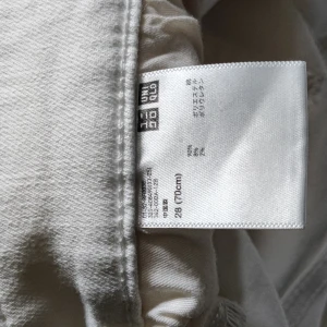 Vita skinny jeans från Uniqlo - Säljer ett par vita skinny jeans från Uniqlo i storlek 28. De har en smal passform och är tillverkade av bomull med lite stretch för extra komfort. Perfekta för dig som gillar en clean och fräsch look.