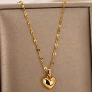 Guldigt halsband med hjärthänge - Snyggt halsband i guld med ett blankt hjärthänge. Kedjan har ett unikt mönster med små platta länkar som ger extra glans. Perfekt för dig som gillar klassiska smycken med en romantisk touch. Hängsmycket är i form av ett hjärta och hela halsbandet har en lyxig känsla.