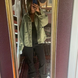 Grön jeans jacka - Säljer en snygg ljusgrön jeans jacka med stora fickor framtill och knappar hela vägen. Jackan har en loose passform och är perfekt att slänga över en t-shirt. Den har klassisk krage och coola detaljer som gör den extra trendig.