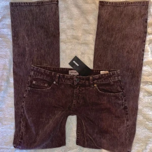 Lågmidjade bootcut jeans - Säljer ett par HELT NYA jeans från Weekday då jag beställde hem två par i olika storlekar!  Dem är bruna med ränder som liknar manchester-tyg. De sitter jättefint och har som sagt en unik färg som syns bäst på de två första då det är olika ljus💕  Storlek 38 Midjemått (rakt över) 39cm Innerbenslängd  80cm