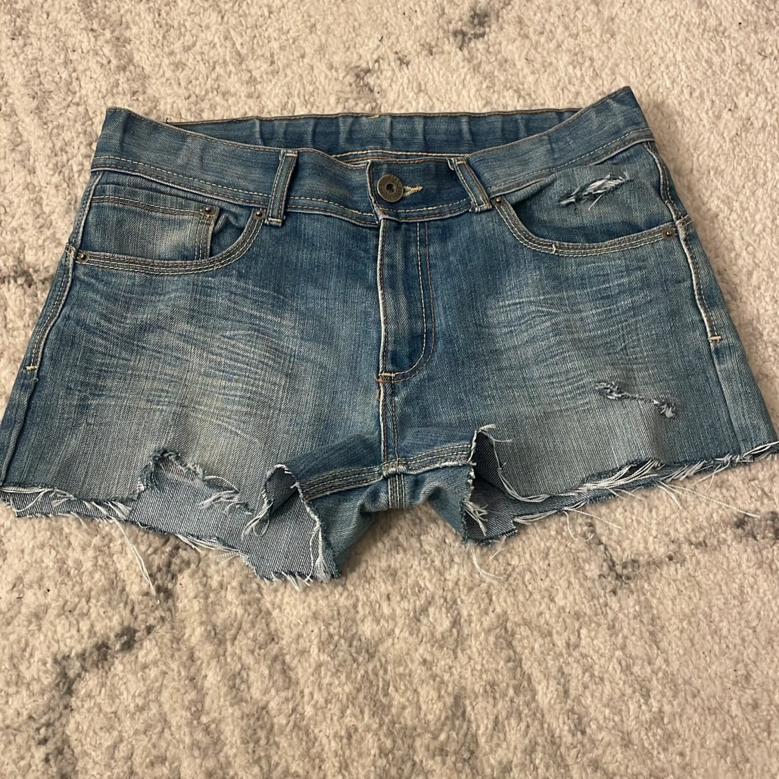 Blå jeansshorts med slitningar