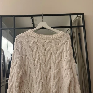 Vit stickad tröja från Gina Tricot - Säljer en chunky vit stickad tröja från Gina Tricot med grovt flätmönster och rund hals. Perfekt för lager-på-lager och riktigt cozy vibes. Långärmad och i mjuk bomullskvalitet. Superfin till både jeans och kjol! Säljer denna tröja för den tyvärr är för stor🫶🏼
