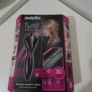 BaByliss Twist Secret Starter Kit - BaByliss Twist Secret Starter Kit för snabba och enkla flätor. Inkluderar 30 tillbehör för kreativ styling. Produkten ser komplett ut men kartongen har tydliga skador och slitage. Perfekt för att skapa olika frisyrer hemma.