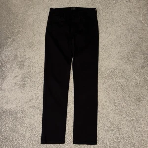 Svarta jeans från Neuw - Svarta jeans från Neuw med klassisk femficksdesign och smal passform. Snyggt minimalistiskt läderpatch med Neuw Stockholm/Melbourne 2009 på baksidan. Jeansen är raka och tighta hela vägen ner, perfekta för en clean look.