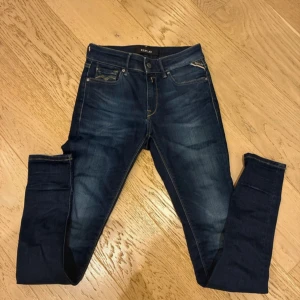 Replay mörkblå skinny jeans - Snygga mörkblå jeans från Replay med klassisk femficksdesign och gul kontrastsöm. Modellen är skinny med smal passform och låg midja. Jeansen har Replay-logga på bakfickan och patch i midjan. Perfekta för dig som gillar en tajt siluett.