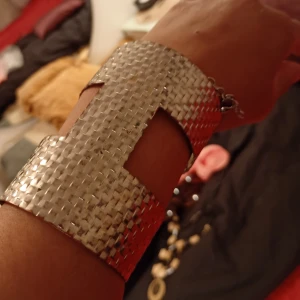 Silvriga breda metallarmband - Två coola breda armband i silverfärgad metall med ett unikt, flätat mönster och geometriska utskärningar. De har en chunky och edgy vibe som sticker ut och passar perfekt om du vill ha något som syns. Säljs som par.