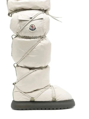 Moncler Gaia Pocket High Moon Boots - Oanvända , Supersnygga och unika beige Moncler Gaia Pocket High moon boots med quiltad design, snörning runt hela skaftet och en liten ficka med Moncler-logga. Skorna har en tjock, svart platt sula och är tillverkade i syntetmaterial som påminner om en dunjacka. Perfekta för vinter och snö! Inköpta för 11.115kr äkthetsintyg från Moncler, dustbag  och originalkartong medföljer.