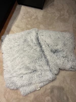 Ljusgrå fluffiga kuddar och filt - Ett par fina kuddar och filt från jysk som inte kommit till användning! 🩷 Kuddarna är 50x50 