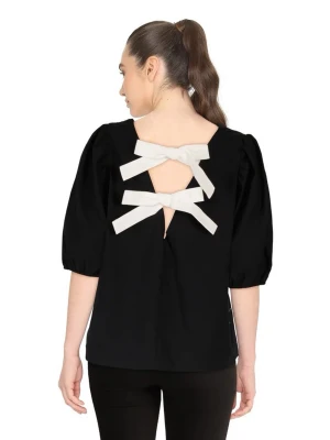 Svart kortärmad tröja med vita rosetter, puff ärmar  - Svart tröja med puffärmar och med vita rosetter som går att ha både fram och baktill. Skicket är mycket bra. Oklart vart tröjan är ifrån.  Storleken är S