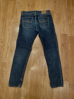 Nudie Jeans Steady Eddie II blå jeans - Säljer ett par Nudie Jeans Steady Eddie II i färgen Blue Slate. Klassiska blå jeans med raka ben, fem fickor och knappgylf. Tillverkade i 100% bomull för en autentisk jeanskänsla. Snygga kontrastsömmar och diskret broderi på bakfickorna.