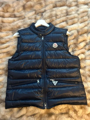 Moncler gui - Go vest från moncler i marinblå som är i strl S/1 som passar dig som är 170-180 och är stilren och go, triangel taggen medföljer
