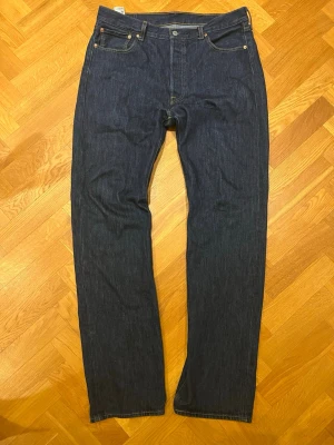 Levis 501 - Levis 501 jeans mörkblå raw denim, små tecken på slitage på båda benen vid botten
