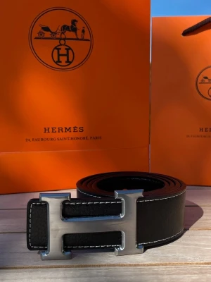 Svart Bälte | 105 cm | Helt Ny  - Svart designer bälte med ett silvrigt H spänne  Storlek: 105cm (Storlek 42)  Helt nytt aldrig använt, skickas inom 24h!