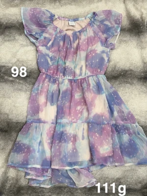 Pastellfärgad klänning - Supersöt klänning i pastellfärger. Klänningen har volangdetaljer och korta ärmar i ett tunt, luftigt material. Perfekt för sommarens alla äventyr!🌸 Fint använt skick, storlek 98 