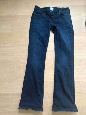 Svarta Molly bootcut jeans från l.t.b - Säljer ett par svarta Molly jeans från l.t.b med bootcut-modell och låg midja. Jeansen har klassisk femficksdesign och är tillverkade i mjukt denimtyg som sitter snyggt på benen. Perfekta för dig som gillar en tidlös look med lite utsvängda ben.