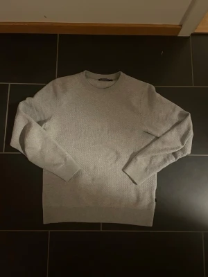 Ljusgrå stickad tröja J.Lindeberg - Säljer en ljusgrå stickad tröja från J.Lindeberg i 100% bomull. |  Tröjan är i storlek S, passar dig bäst runt 175-179. | Tröjan är i mycket bra skick, inga defekter. | Vid fler frågor är det bara att skriva 😊