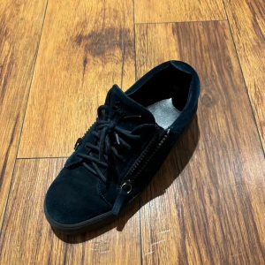 Giuseppe Zanotti skor - Otroligt snygga mörkblå skor från Giuseppe Zanotti i mocka med svarta snören och coola dragkedjor på sidorna. Perfekta för dig som gillar stilrena detaljer och vill ha något som sticker ut lite extra. Köpta i Italien för lite över ett år sedan men har knappt använts och tagit hand om de väldigt bra. Kommer med låda och dustbag. Det är bara ställa på frågor om det är något du undrar om skorna eller priset😁