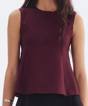 Vinröd ärmlös peplum topp  - Säljer en stilren vinröd peplum topp. Toppen är ärmlös med rund hals och har en lätt utsvängd passform som ger en snygg siluett. Materialet är mjukt och har en slät yta, perfekt för att lyfta din look. Passar dig som gillar minimalistisk stil.