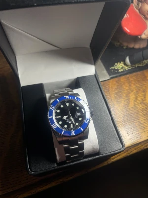 Seiko ”Smurf” Mod - Helt nybyggd Seiko ”smurf” Mod  Specifikationer: Storlek: 40mm Urverk: Nh35 (Automatiskt) Material: 904L Rostfritt Stål Glas: Sapphire Glas Tavla: Svart  Bezel: Blå Armband: Viklås och Justerbart  Krona: Screw Down Vattentålighet: 30 Meter Klocklåda ingår