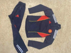 Manchester United träningsset Adidas - Säljer ett mörkblått Manchester United träningsset från Adidas med röda och gula detaljer. Setet består av långärmad tröja med klubbmärke, vita ränder på ärmarna och matchande byxor med röda loggor och vita ränder. Perfekt för fotbollsträning.