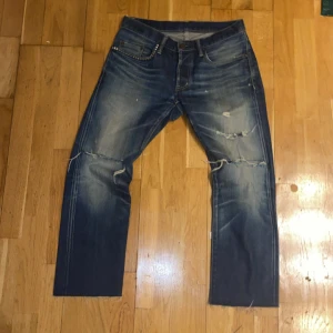 Selvedge Jeans - Säljer ett par klassiska Hysteric Glamour jeans i blå tvätt med coola slitningar och trasiga detaljer på knäna. Jeansen har raka ben och rå kant. Säljer billigare eftersom jag har klippt där nere. Hör av vid funderingar!