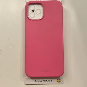 Holdit Silicone Case för iPhone 12/12 Pro - Snyggt rosa silikonfodral från Holdit, anpassat för iPhone 12 och 12 Pro. Ger ett bra grepp och skydd mot repor och stötar. Fodralet är nytt och levereras i originalförpackning. Perfekt för dig som vill ge din iPhone ett färgglatt och stilrent skydd.