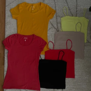 Färgglada toppar och linnen i bomull - Säljer ett paket med två t-shirts i rött och gult samt fyra linnen i svart, rött, beige och ljusgul. T-shirtsen har rund hals och kort ärm, linnena är ärmlösa med smala axelband. Alla i mjuk bomull, perfekta för sommaren och att mixa och matcha. xs-s